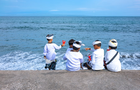 Bali, Indonesia - March 25, 2017: Local young faithful during a religious ceremony on the seashoreのeditorial素材
