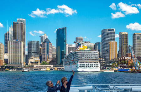Sydney, Australia - October 16, 2014:  Touirsts on a boat with the harbor and the Quay Staion towers in the backgroundのeditorial素材