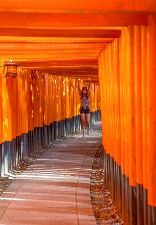 Kyoto, Japan - April 20, 2018: A young lady on the path of the One Thousand Torii Gates of the Fushimi Inari Taisha templeのeditorial素材