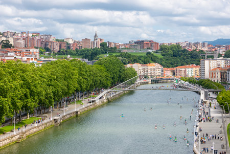 Bilbao, Spain - June 14, 2018: Water sports on the Nervion river with the Zubizuri bridge in the backgroundのeditorial素材