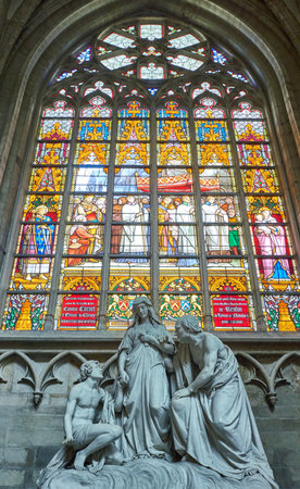 Brussels, Beigium - September 5, 2018: A sacred marble group in front of a colorful stained glass, on the Saints Michael and Gudule Cathedralのeditorial素材