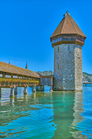 Lucerne, Switzerland, the wooden covered Chapel bridge with the octagonal Water tower on the Reuss riverの写真素材