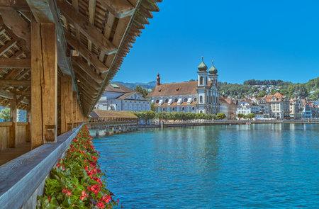 Lucerne, Switzerland, the old town with the Jesuit church seen from the wooden covered Chapel bridge on the Reuss riverの写真素材