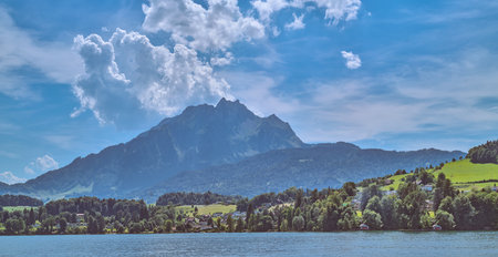 Lucerne, Switzerland, houses and fields on the Lucerne lake with the Pilatus mountain in the backgroundの写真素材
