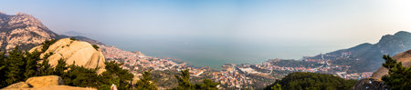 Fishing villages and Yellow sea panorama from Na Luo Yan Ku trail in Laoshan Mountain, Qingdao, Chinaの写真素材