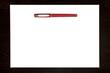 Isolated red pen on a white paper sheet, template ready for your designの写真素材