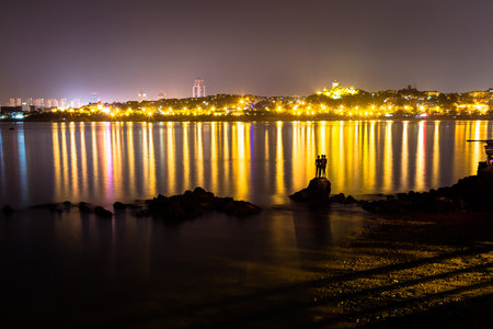Three boys sculpture at night in Huiquan Bay, Yellow sea Shinan district, Qingdao, Shandong province, Chinaの写真素材