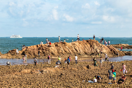 06-08-2016 - Qingdao, China - Tourists taking photos of the rocks of Qingdao Coastline in Taiping Bayのeditorial素材