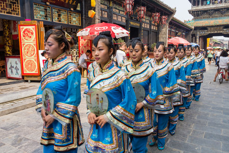 Aug 2013 - Pingyao, Shanxi, China - Traditional costume parade that happens every morning in the South Street of Pingyao, one of the main roads of the old city. Pingyao is a UNESCO world Heritage siteのeditorial素材