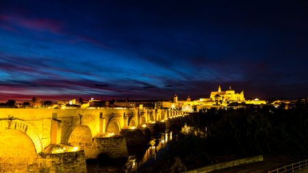 View of Mezquita, Catedral de Cordoba, across the roman bridge at sunset. A former Moorish Mosque that is now the Cathedral of Cordobaの写真素材