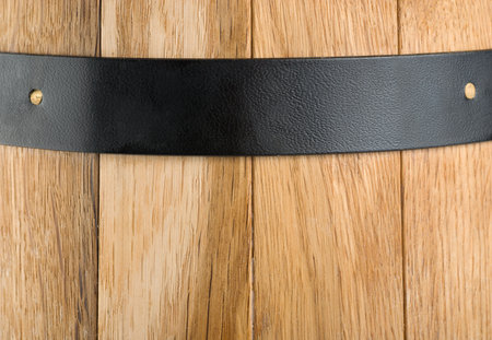 Background of a wooden barrel and a metal stripの写真素材