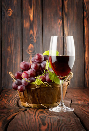 Wine glass and grapes in a basketの写真素材