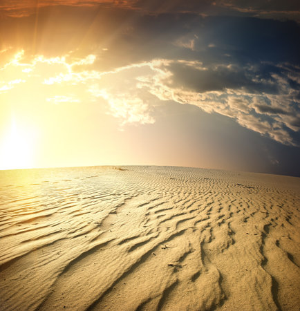 Desert into the sunset and dramatic cloudsの写真素材