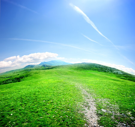 road in a mountain valley on a background of blue skyの写真素材