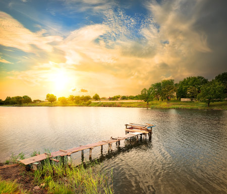 Wooden dock, pier, on a lake in the eveningの写真素材