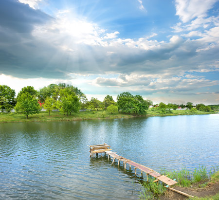 Fishing pier on the river at sunny dayの写真素材