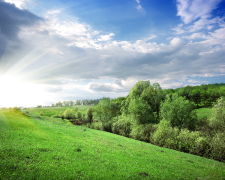Sunbeams over the forest on the hillの写真素材