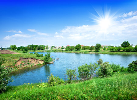 Sun and blue sky over the calm riverの写真素材