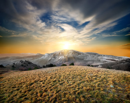 Autumn mountains and dry grass at sunsetの写真素材