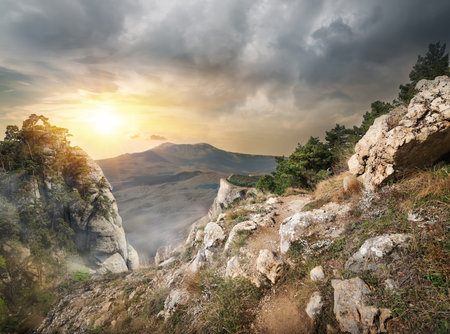 High rocks and gray clouds at sunsetの写真素材