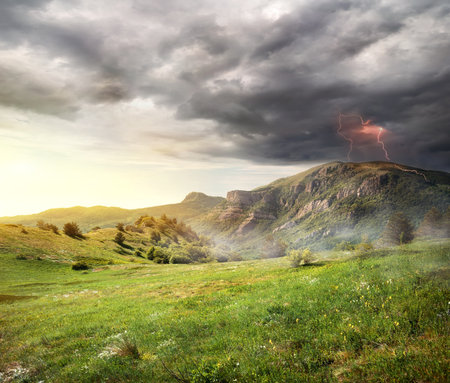 Lightning and storm clouds over the mountainsの写真素材