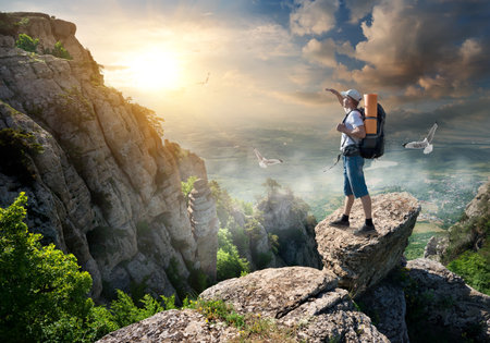 Tourist on the top of a rock at sunriseの写真素材