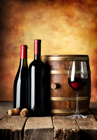 Bottles and cask of wine on a wooden tableの写真素材