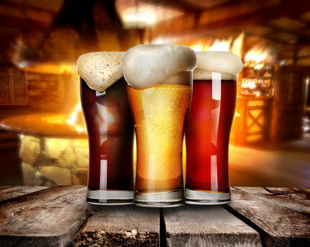 Three glasses of beer on a table in barの写真素材