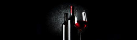 Two bottles and wineglass on a black backgroundの写真素材