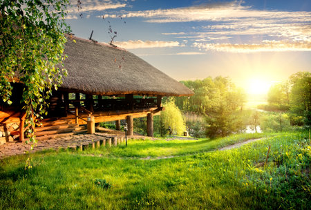 House of log near lake at sunsetの写真素材