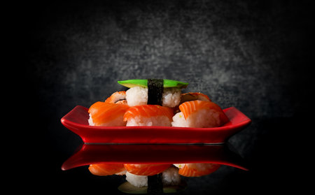 Sushi on a red plate and black backgroundの写真素材