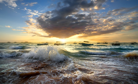Fishing boats in the ocean at sunsetの写真素材