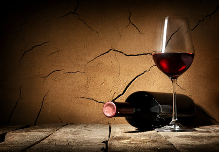 Wine and cracked clay wall in cellarの写真素材