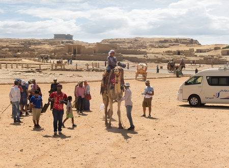 Giza, Egypt, August 13. 2015: Tourists near camel and ruins of pyramids in egyptian desert. UNESCO World Heritageのeditorial素材