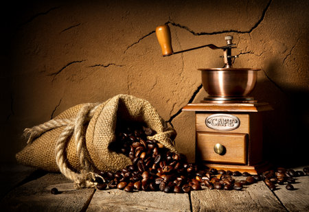 Coffee grains and mill in cellar with clay wallの写真素材