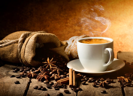 Cup of coffee and spices on wooden tableの写真素材