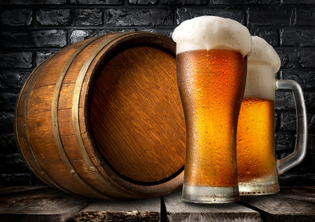 Beer and wooden keg near black brick wallの写真素材