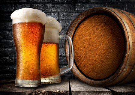 Wooden keg and beer near black brick wallの写真素材