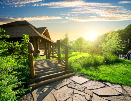 Sunny sunset and house near wooden bridgeの写真素材