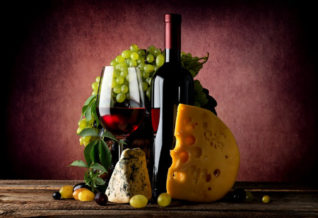 Cheese and wine with grape on vinous backgroundの写真素材