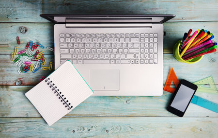 Laptop and stationary on wooden table from aboveの写真素材