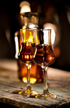 Glass of whiskey and decanter on wooden tableの写真素材