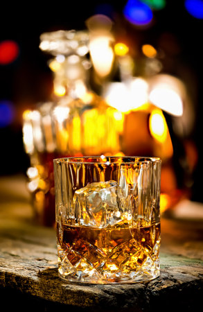 Glass of whiskey and decanter on wooden tableの写真素材