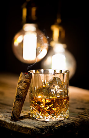 Glass of whiskey and decanter on wooden tableの写真素材