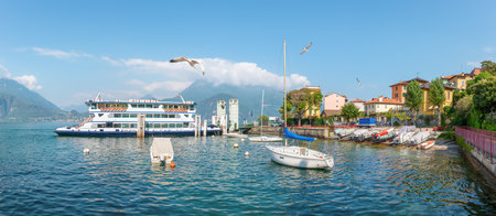 Scenic view of the marina with a ferry in Varenna on Lake Comoの写真素材
