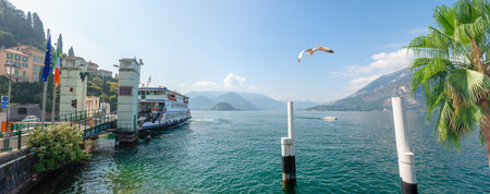 Scenic view of the marina with a ferry in Varenna on Lake Comoの写真素材