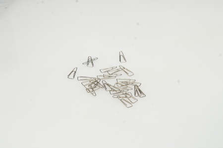 shiny silver paper clips made of iron to clamp paper as work and office supplies