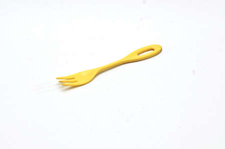 empty plastic fork made of yellow with a white background