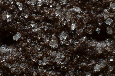 black-brown dry biscuits studded with white granulated sugar at the top which partially sticks to...