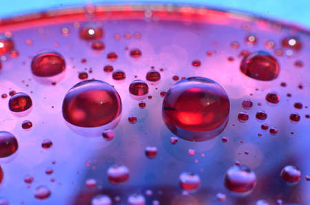 shiny clear water point attached to a glass reflects the same color as the color on the glass into a...